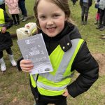 Student smiling holding guide to park.